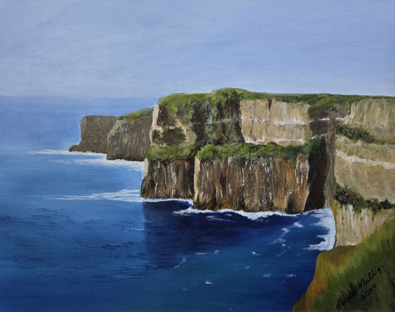 Sheer layered cliffs with green grass along their tops, dropping to deep blue Atlantic water far below