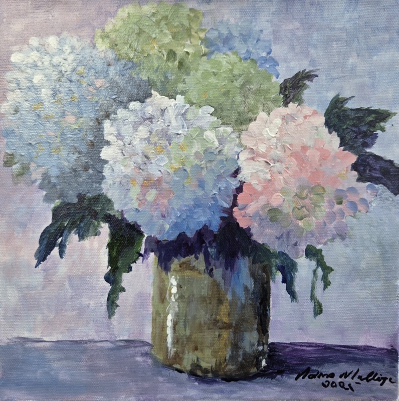 Pale hydrangeas in white, green, blue and pink arranged in an olive-toned tin can against a soft lilac ground
