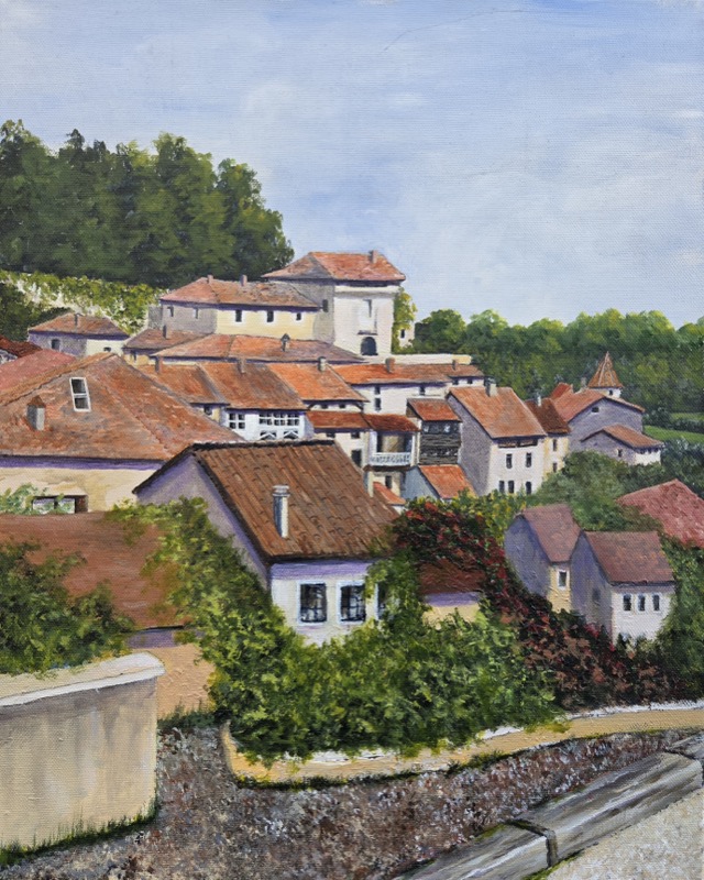 A French hilltop village of terracotta roofs and pale walls, climbing between wooded slopes